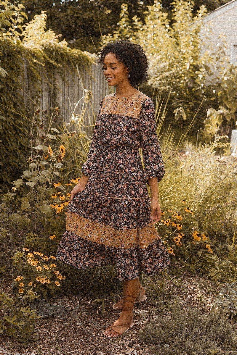 Our model of African American descent featured in a beautiful sunflower garden wearing our flower themed maxi dress. Want to discover more? Continue on to shop now for our latest arrivals in the dresses category.